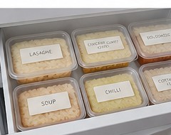 Batch-cooked meals labelled and stacked in the freezer